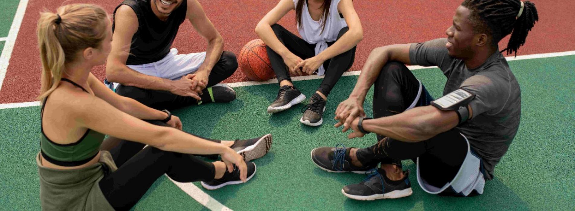 4 pessoas reunidas sentadas em uma quadra